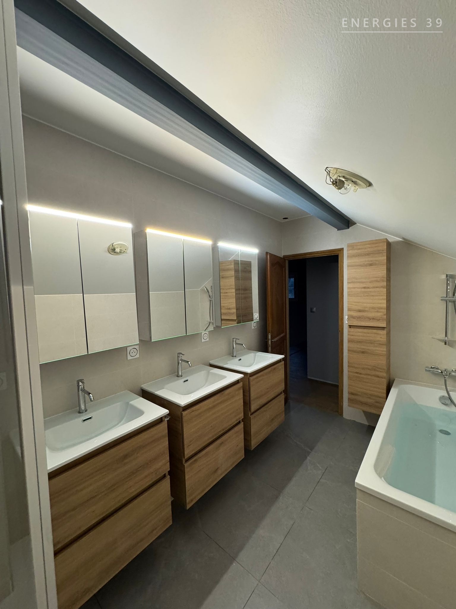 Grande salle de bain familiale avec triple vasque en bois et baignoire